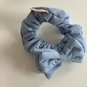 Sweet light blue fabric bow scrunchie with natural texture for elegant hairstyles