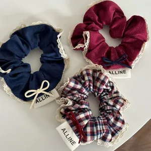 Three-piece red and navy plaid hair scrunchie set with white lace trim and bows