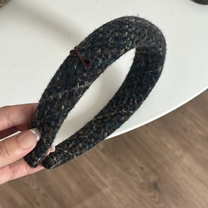 Close-up of thick tweed headband with sponge padding and small bow detail