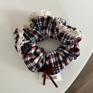 Classic red plaid scrunchie with white lace trim and delicate bow detail for hair