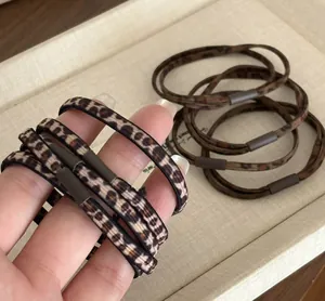 Vue détaillée d'élastiques à cheveux léopard haute élasticité en marron et beige