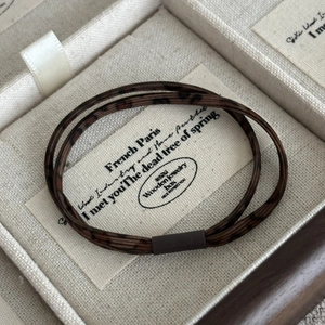 Détail d'élastiques à cheveux imprimé léopard dans un coffret à bijoux en bois
