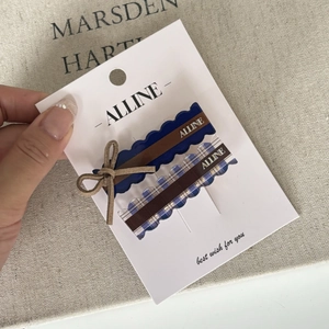 Detail of blue and brown bow hair clips on display card with stylish prep style design
