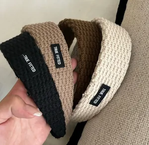 Close-up of four knitted headbands in black, beige, and brown with True Fitted labels