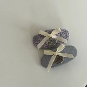 Detailansicht der lila Tweed und grau gestreiften Haarklammern mit eleganten beigen Schleifen
