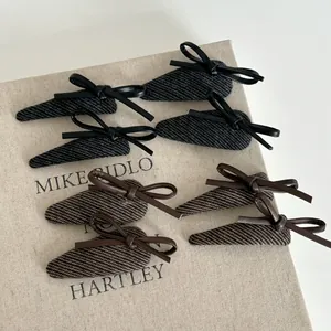Detail of 8pcs vintage leather bow hair clips with textured herringbone fabric patterns