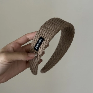 Close-up detail of the brown knit headband texture with True Fitted woven label
