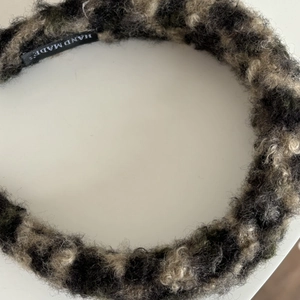 Detail shot of plush leopard print headband with a woven black Hand Made fabric label