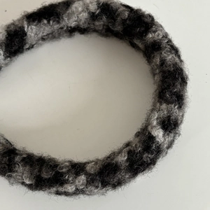 Close-up of black and grey leopard faux lamb wool texture on plush hair headband