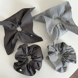 Elegant grey striped fabric scrunchies set with ribbons and metal brand charms