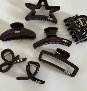 Détails de pinces à cheveux marron chocolat avec ressorts dorés et marquage de logo