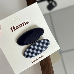 Set of two oval hair clips in black and houndstooth pattern on a white display card