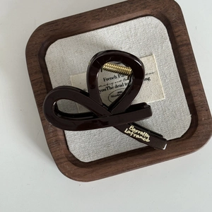 Gros plan sur la pince à cheveux marron chocolat avec logo Barrette La France doré