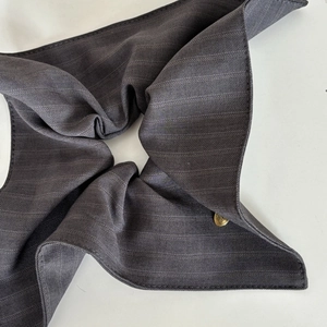 Elegant dark grey striped fabric scrunchie with a gold metal decorative buckle logo