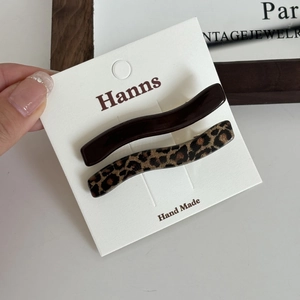 Detail showing wave-shaped leopard print and brown hair clips on a white display card