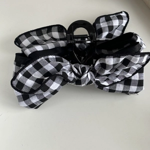 Classic black and white plaid bow hair claw clip with silver label and sleek back grip