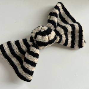 Elegant knit bow hair accessory featuring classic black and white horizontal stripes on white