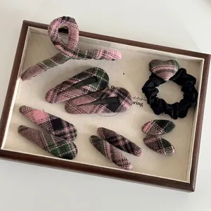 Pink plaid hair accessory set with tweed claw clip and heart elastic on wooden tray