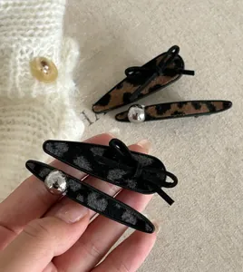 Detail of leopard print hair clips with velvet texture and silver bead embellishments