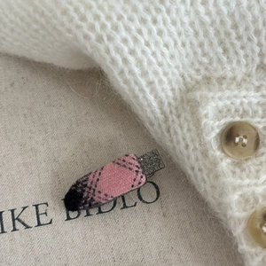 Elegant pink plaid fabric hair clip with shimmering rhinestones on a beige rustic background