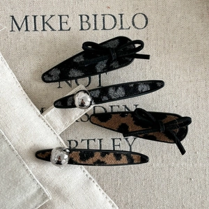 Set of 4 leopard print hair clips with black bows and silver metal bead details