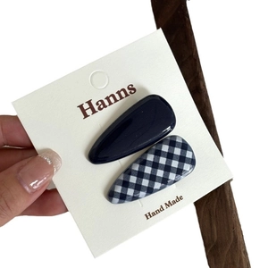 Blue gingham and navy resin heart-shaped hair clips set on a display card