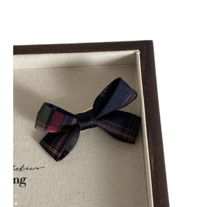 Navy blue plaid bow hair clip featuring classic tartan fabric in a vintage display box