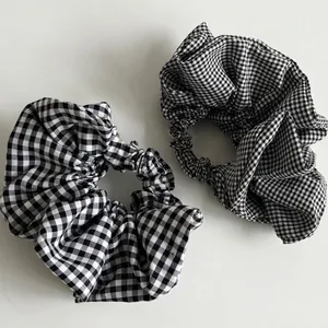 Set of two black and white houndstooth check scrunchies with elastic hair tie design