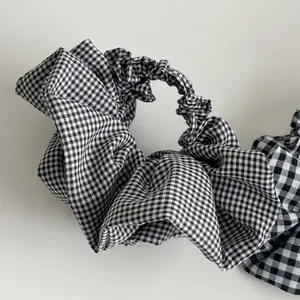 Detailed view of the black and white gingham oversized scrunchie with layered ruffles