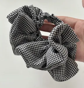 Close-up of handmade black and white gingham checkered hair scrunchie with soft fabric texture