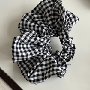 Classic black and white gingham scrunchie with pleated fabric for elegant hairstyles