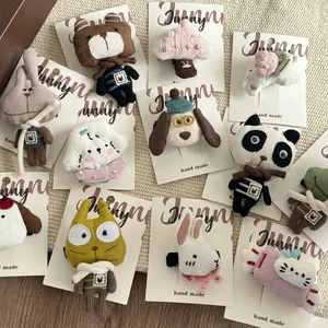 Assorted plush cartoon hair clips with embroidery and pearls on a beige mat