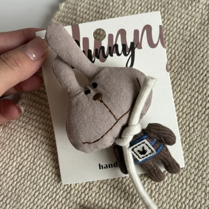 Cute Korean style stuffed bunny hair clip on a display card held by a hand for girls