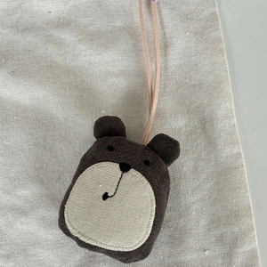 Détail d'un ours en tissu fait main en coton et lin marron avec broderie soignée