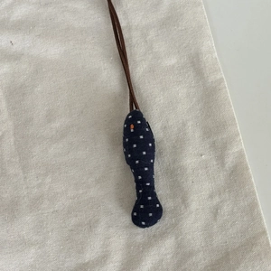 Détail d'un pendentif en forme de poisson en tissu fait main avec broderie