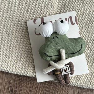 Detailed view of a handmade green crocodile hair clip with knitted fabric and funny round eyes