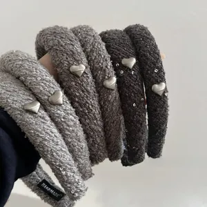 Vue détaillée de serre-têtes en tissu gris avec cœurs argentés et étiquette fait main
