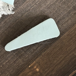 Close-up of mint green plaid fabric texture on a minimalist vintage style hair clip