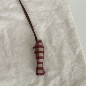 Détail d'un pendentif en forme de poisson en tissu à carreaux fait main avec cordon