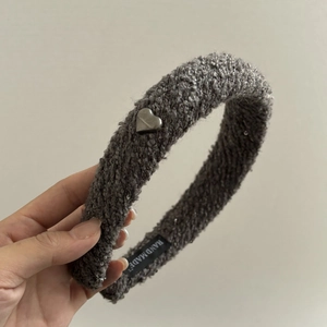 Serre-tête en polaire grise avec un pendentif cœur argenté et étiquette artisanale