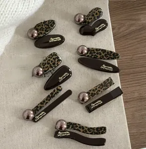 Detail view of French leopard print and chocolate brown hair clips with pearl accents