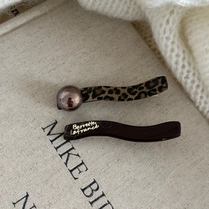 Detail of French leopard print hair clip set with brown pearl and golden Barrette La France text