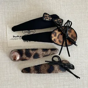 Set of four leopard print hair clips with bows and pearls for a vintage elegant look