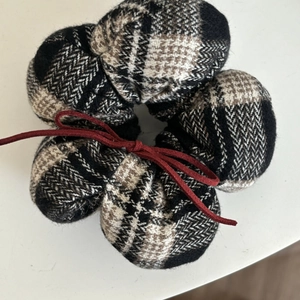 Plaid scrunchie accessory in black and white check pattern with a dark red bow tied on it
