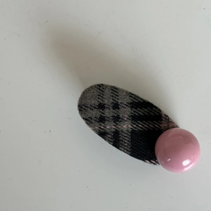 Detail of pink and grey plaid fabric hair clip featuring a large glossy resin bead accent