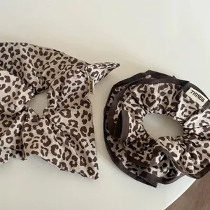 Brown leopard print oversized scrunchie set with stylish textile label on beige background