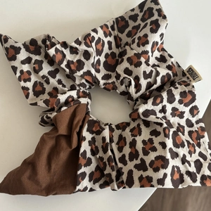 Detail of leopard print scrunchie with THINGS fabric label and stitched texture