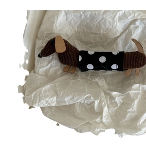Niedliche braune Cord-Dackel-Haarklammer mit einer schwarz-weißen Polka-Dot-Stoffschleife