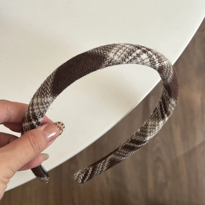Detail of checkered knit headband in coffee and beige with thick tweed texture
