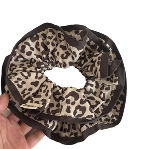 Brown leopard print oversized hair scrunchie with dark brown piping and fabric tag